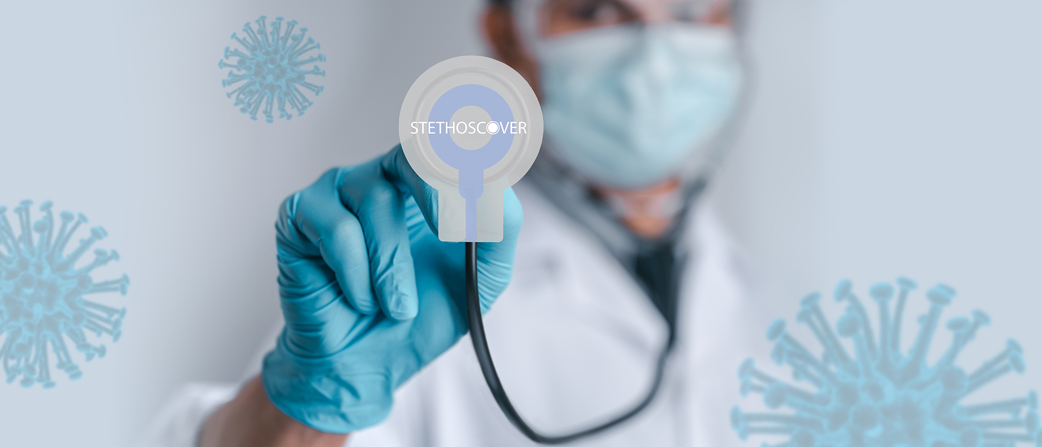 A clinician holding a stethoscope fitted with a Stethoscover barrier
